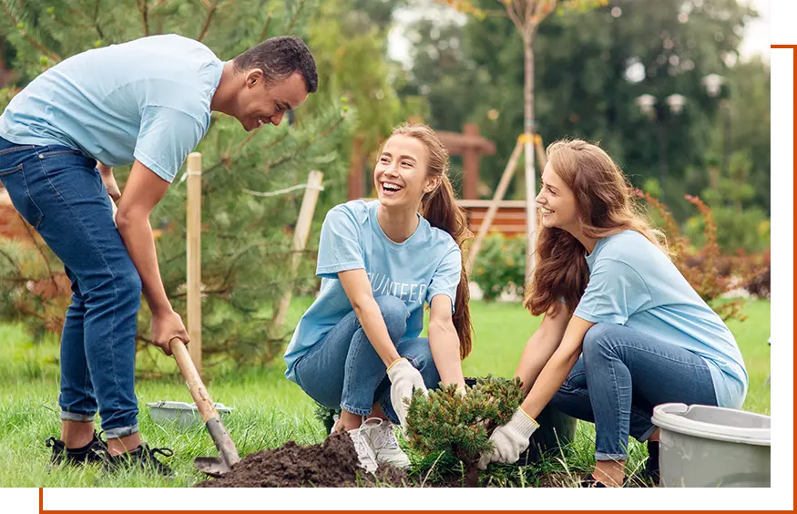 Man and 2 women planting trees for community outreach